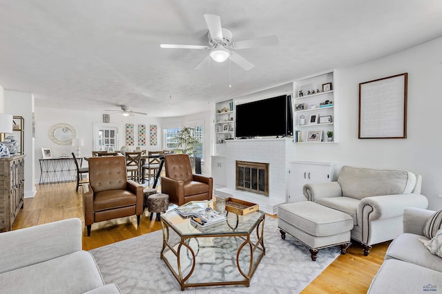 1016 W Blvd, Rapid City, SD 57701 - living room featuring light wood-style floors, ceiling fan, a fireplace, and built in features