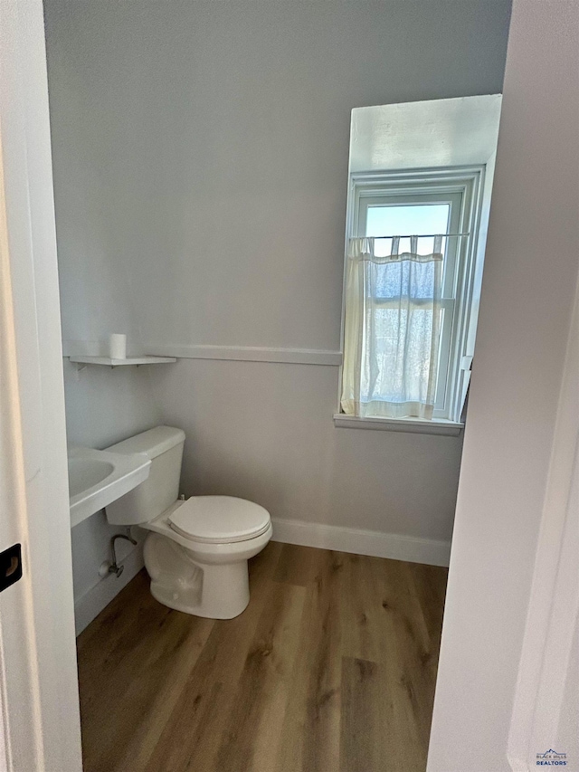 1016 W Blvd, Rapid City, SD 57701 - half bath featuring toilet, baseboards, and wood finished floors