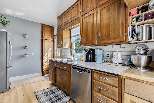1016 W Blvd, Rapid City, SD 57701 - kitchen featuring stainless steel appliances, a sink, light countertops, decorative backsplash, and brown cabinets