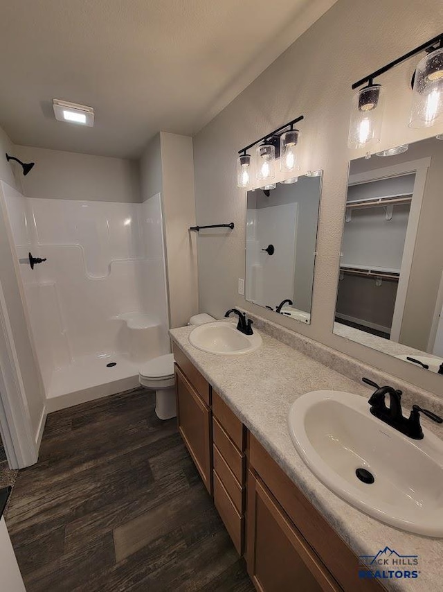 1154 Cobalt Dr, Rapid City, SD 57701 - full bathroom with wood finished floors, a shower, double vanity, and toilet