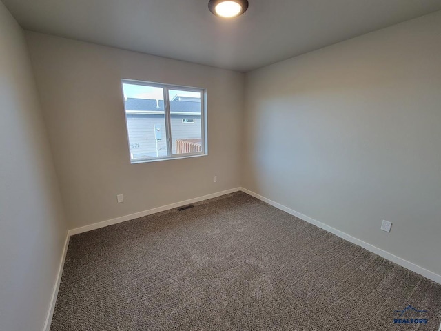 1154 Cobalt Dr, Rapid City, SD 57701 - empty room with dark colored carpet and baseboards