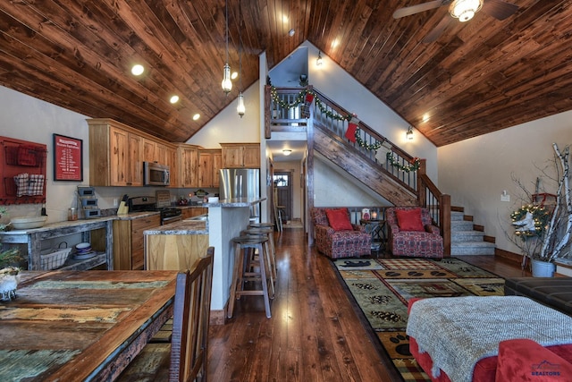 kitchen with stainless steel appliances, dark wood-type flooring, open floor plan, high vaulted ceiling, and wooden ceiling