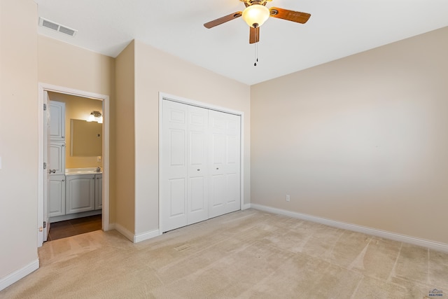 unfurnished bedroom with light carpet, a closet, visible vents, and baseboards