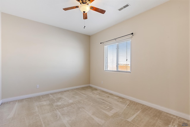 empty room featuring light carpet, ceiling fan, visible vents, and baseboards