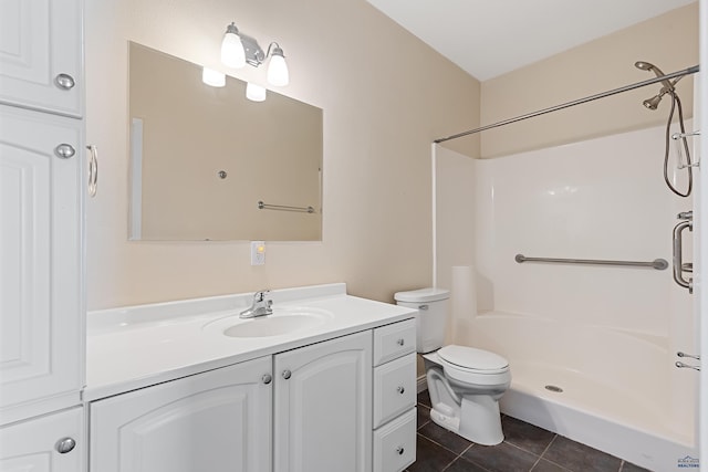 bathroom with toilet, vanity, a shower, and tile patterned floors