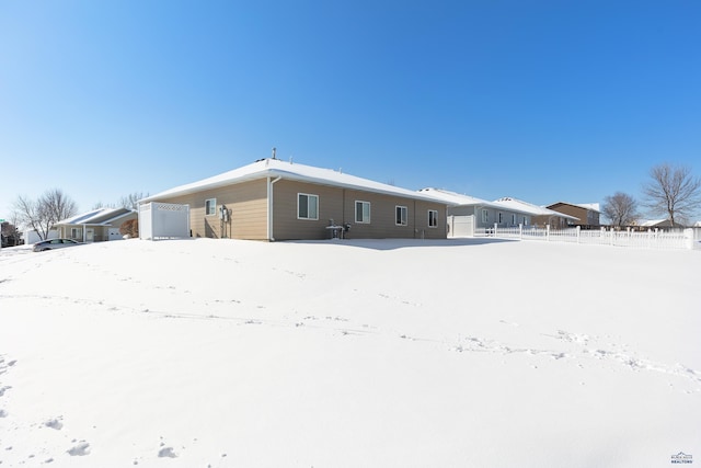 snow covered property featuring fence