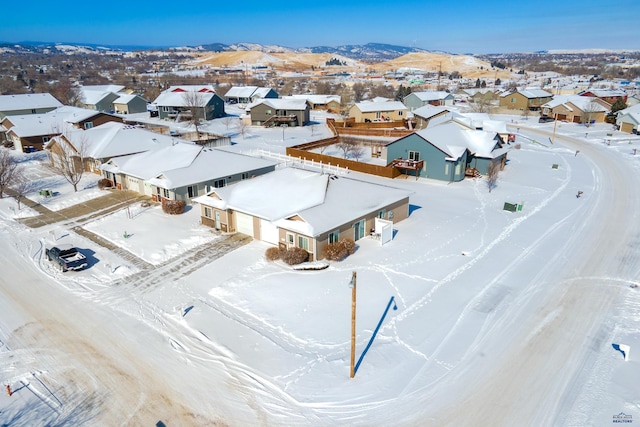 snowy aerial view with a residential view and a mountain view