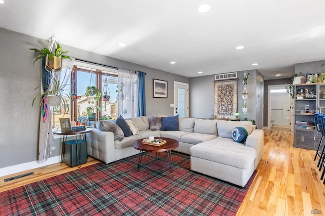 living room featuring wood finished floors, visible vents, and recessed lighting