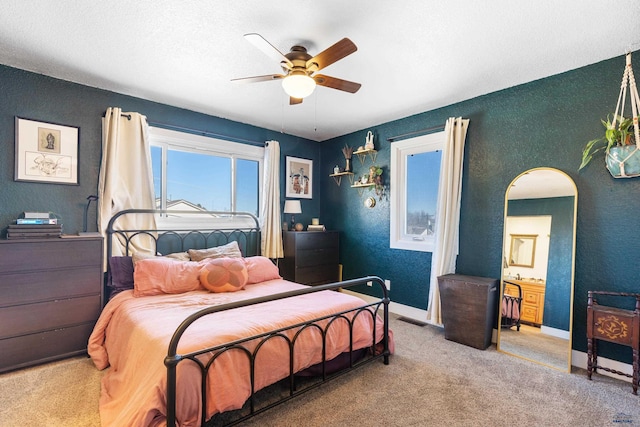 bedroom featuring arched walkways, visible vents, a textured wall, carpet flooring, and baseboards