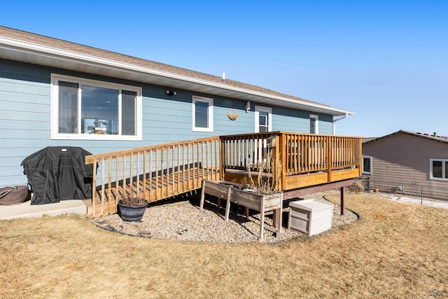 rear view of house featuring a deck and a lawn