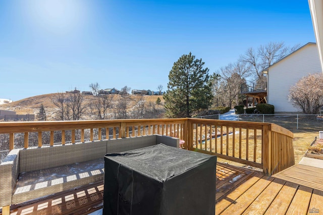 wooden deck featuring outdoor lounge area, a mountain view, and fence