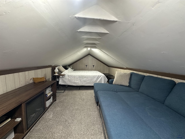 bedroom with light carpet, wood walls, and vaulted ceiling