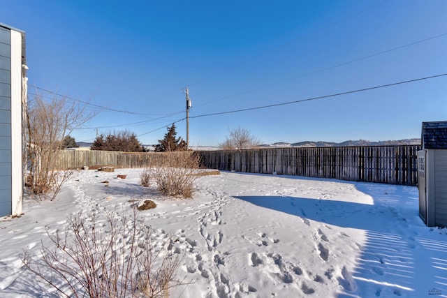 yard covered in snow featuring fence