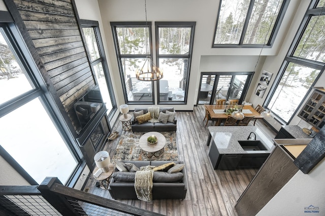 21268 Rubys Way, Lead, SD 57754 - living room with a wealth of natural light, a notable chandelier, a high ceiling, and wood finished floors
