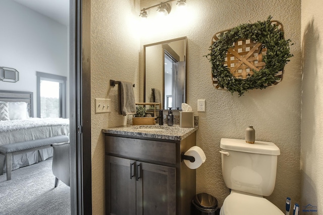 21268 Rubys Way, Lead, SD 57754 - bathroom with a textured wall, connected bathroom, vanity, and toilet