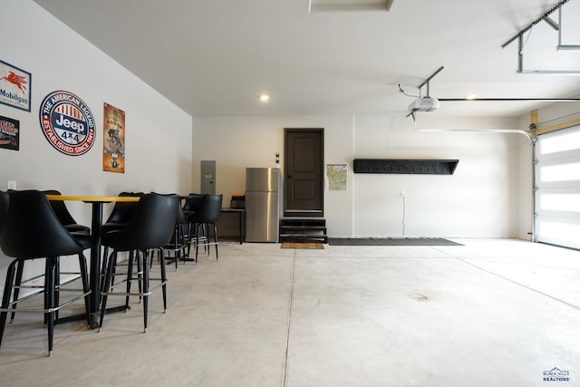 21268 Rubys Way, Lead, SD 57754 - garage featuring a garage door opener, freestanding refrigerator, and electric panel