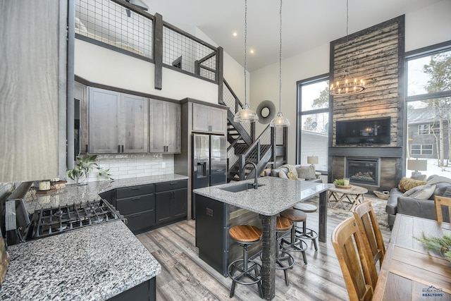 21268 Rubys Way, Lead, SD 57754 - kitchen with a breakfast bar area, a sink, open floor plan, an island with sink, and a glass covered fireplace