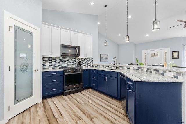 kitchen featuring white cabinets, blue cabinets, hanging light fixtures, stainless steel appliances, and a sink