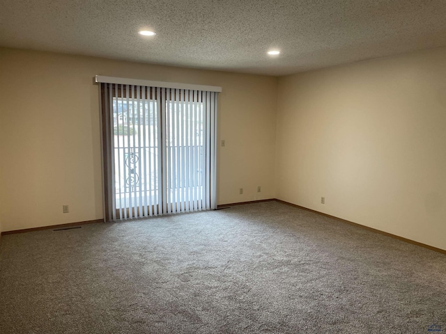 empty room with carpet flooring, a textured ceiling, and baseboards