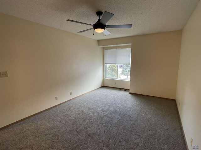 carpeted empty room featuring visible vents, baseboards, ceiling fan, and a textured ceiling