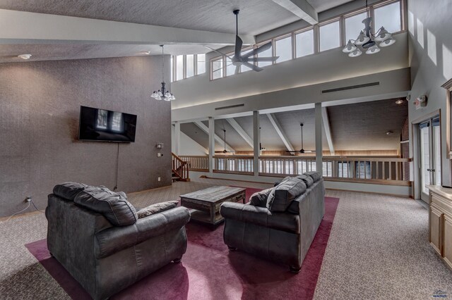 living room featuring a towering ceiling, visible vents, beamed ceiling, and ceiling fan with notable chandelier