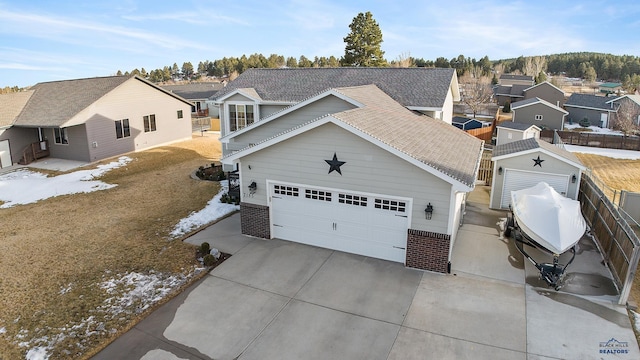 view of front of home featuring concrete driveway, brick siding, an attached garage, and a residential view