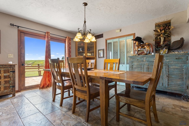 dining space with visible vents, a textured ceiling, and an inviting chandelier