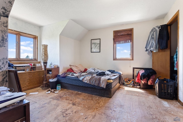 bedroom with a textured ceiling and wood finished floors