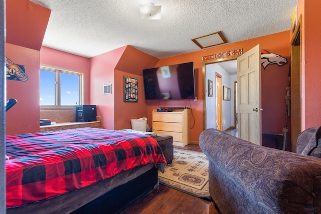 bedroom with a textured ceiling, wood finished floors, and baseboards