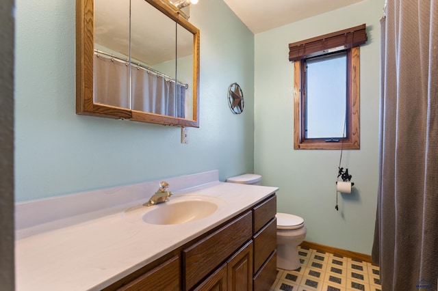 bathroom with curtained shower, toilet, vanity, baseboards, and tile patterned floors