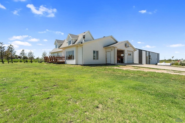 view of front of home with a deck, driveway, a front yard, and a garage