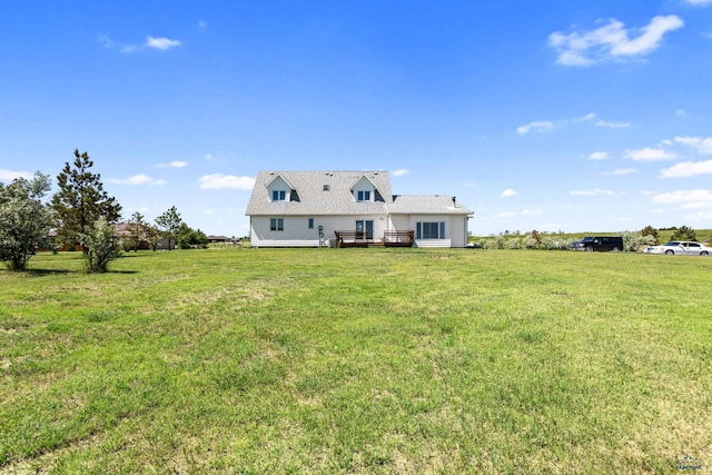 rear view of house with a deck and a yard