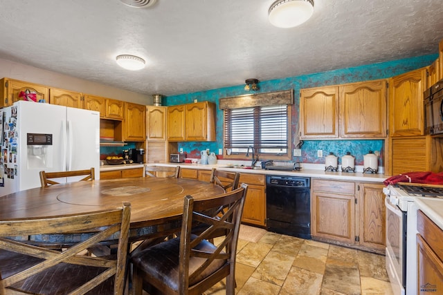 kitchen with black appliances, light countertops, a sink, and brown cabinetry