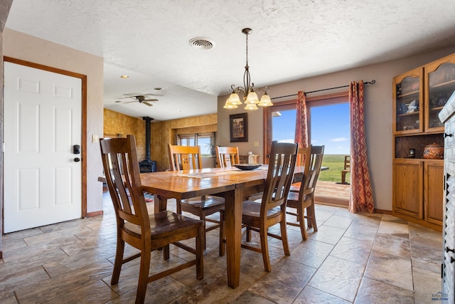 dining room featuring a textured ceiling, visible vents, a chandelier, and a wealth of natural light