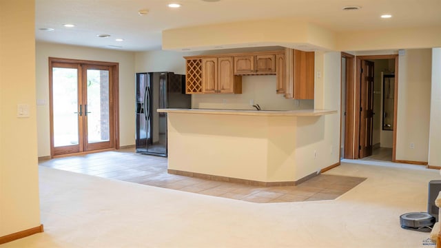 kitchen with french doors, recessed lighting, light countertops, black refrigerator with ice dispenser, and baseboards