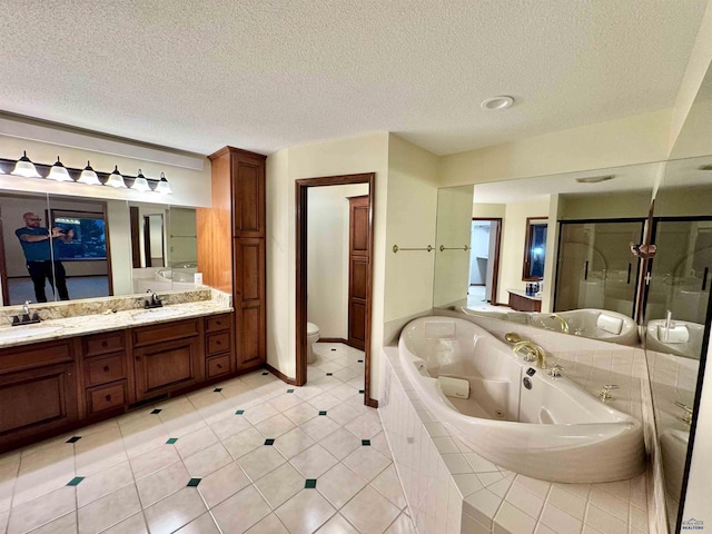 full bathroom featuring double vanity, toilet, a textured ceiling, a shower stall, and a tub with jets