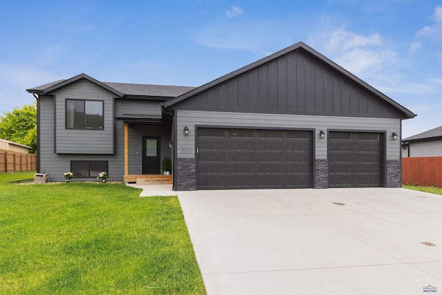 view of front of property with a front yard, fence, a garage, stone siding, and driveway