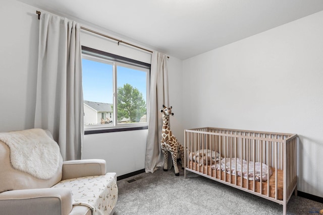 carpeted bedroom with a nursery area, visible vents, and baseboards