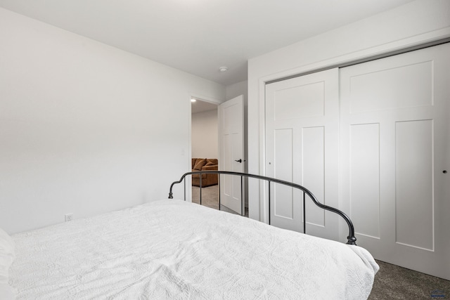 bedroom with a closet and dark carpet