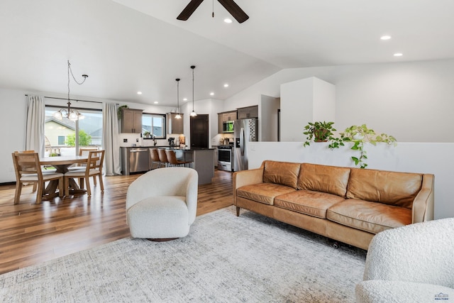 living area featuring lofted ceiling, wood finished floors, and recessed lighting