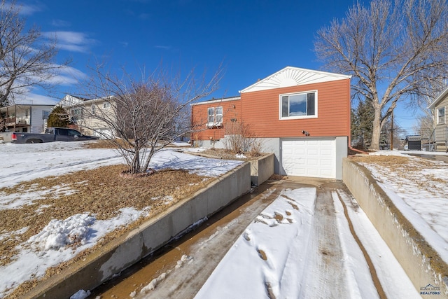 view of snowy exterior featuring an attached garage