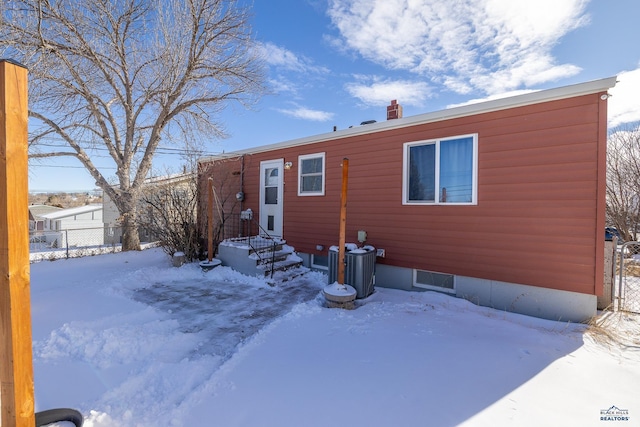 manufactured / mobile home with a chimney and fence