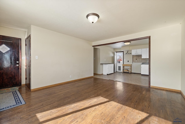 unfurnished living room with dark wood-style floors and baseboards