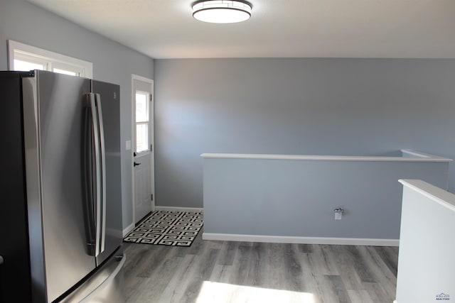 kitchen featuring wood finished floors, freestanding refrigerator, and baseboards