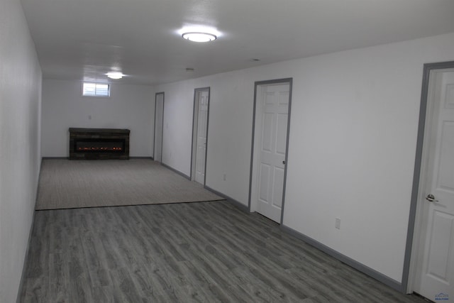 below grade area featuring a fireplace, dark wood finished floors, and baseboards