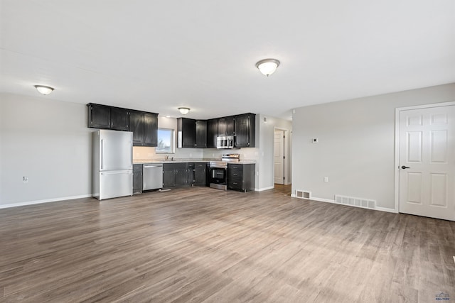 kitchen with visible vents, stainless steel appliances, light countertops, and wood finished floors