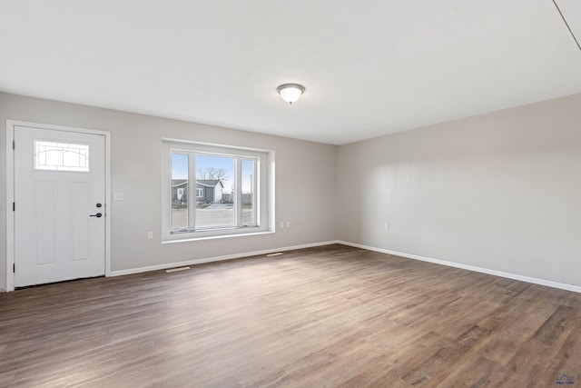 foyer featuring baseboards and dark wood finished floors