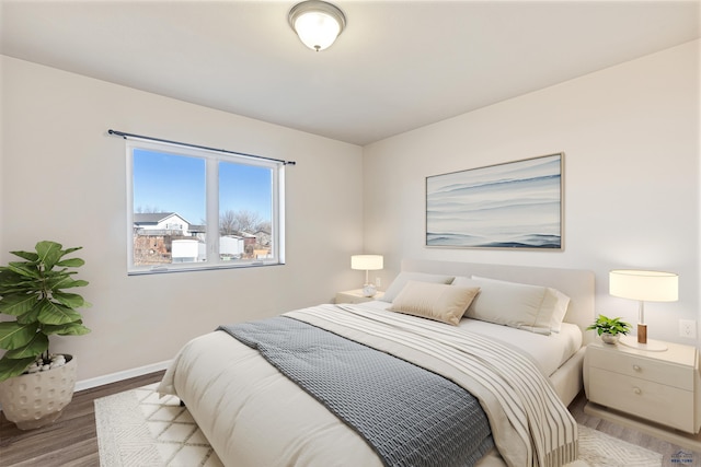 bedroom with baseboards and wood finished floors