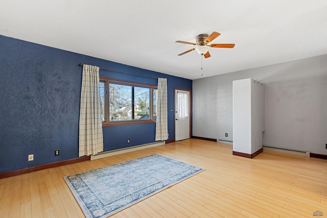 empty room featuring baseboards, ceiling fan, a baseboard radiator, and light wood-style floors