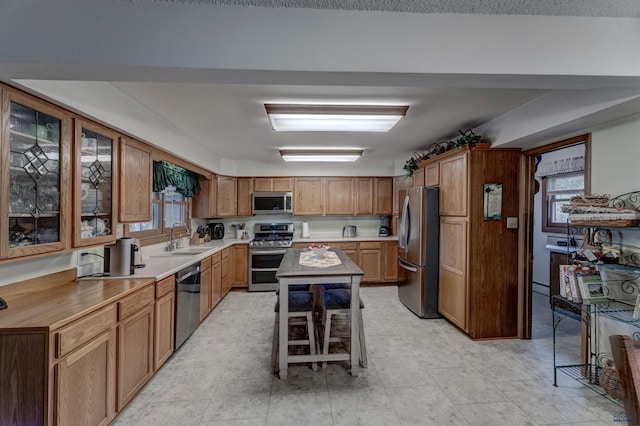 kitchen featuring brown cabinetry, appliances with stainless steel finishes, and light countertops